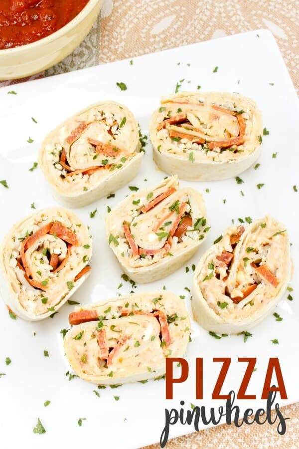 You can make these fun pizza pinwheels in just minutes. Great for a back to school lunch or a busy weeknight meal, these pinwheel pizzas are sure to please. #pinwheels #pizza #pinwheelsandwiches #backtoschool #lunchideas #dinnerrecipes #weeknightmeals #rufflesandrainboots