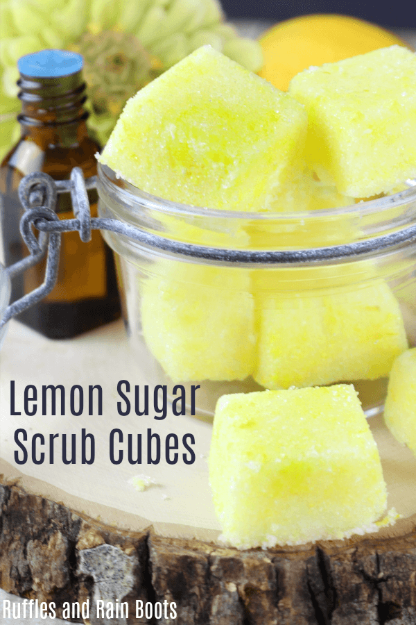 bright yellow lemon sugar scrub cubes with sugar topping in hermetic jar with a jar of scent and a large flower