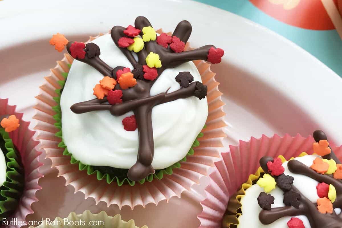 white frosted cupcake with chocolate tree and colorful leaf sprinkles