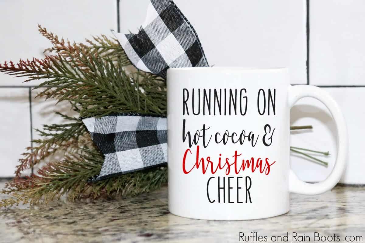 coffee mug on counter with Buffalo check bow and mug which reads Running on Hot Cocoa and Christmas Cheer free SVG