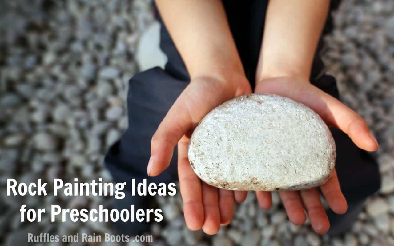 child on beach holding large rock with text which reads Rock Painting Ideas for Preschoolers