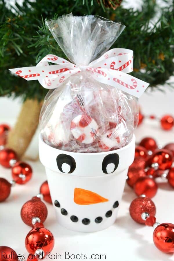 snowman painted terra cotta pot Christmas craft on holiday background