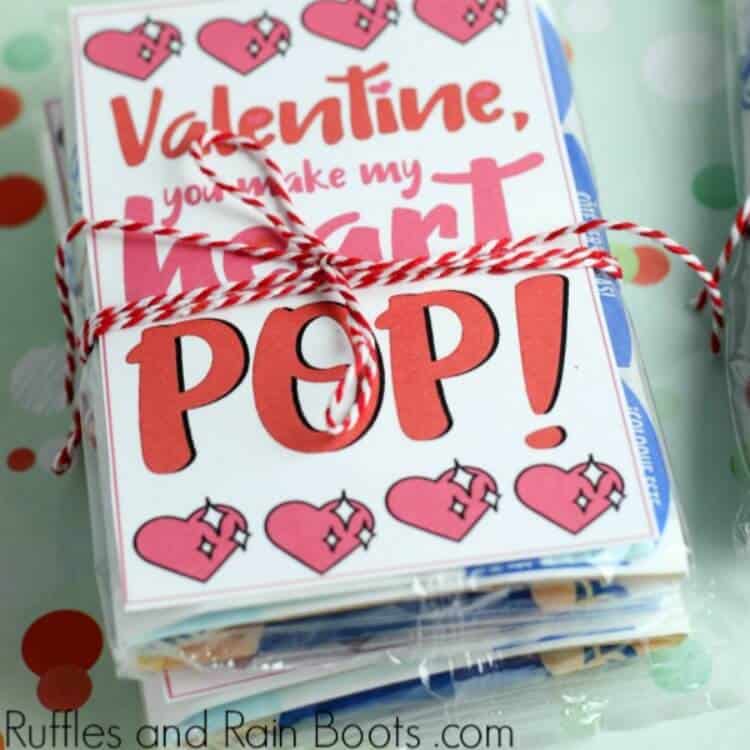 close up of printable popcorn Valentine card on top of a bag of microwave popcorn tied with a red and white twine