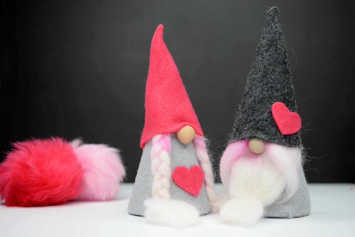 Valentine felt gnomes on black background with pink and gray gnome hat patterns