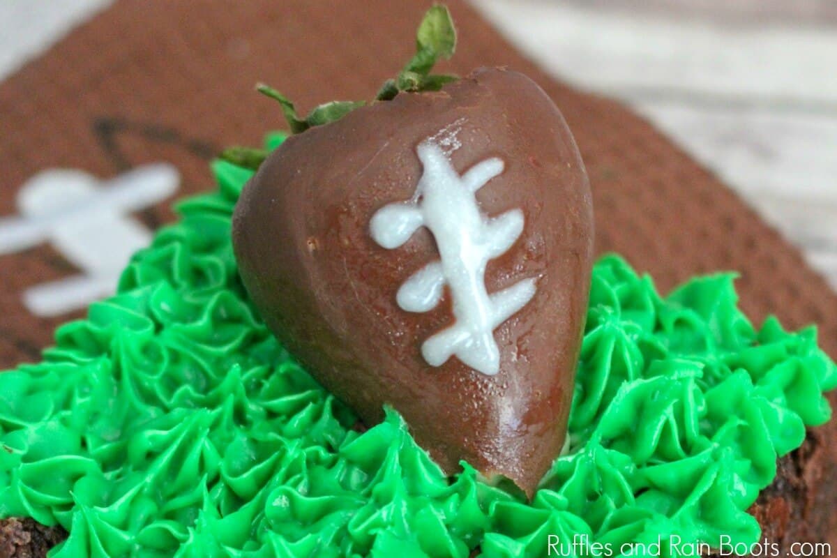 close up of chocolate covered strawberry on football brownie