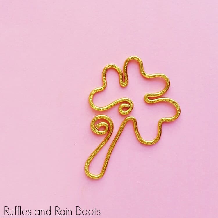 gold shamrock bookmark in wire on pink background