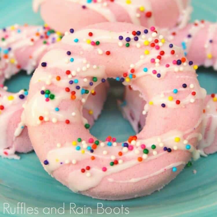 close-up view of pink donut bath bombs on a teal background