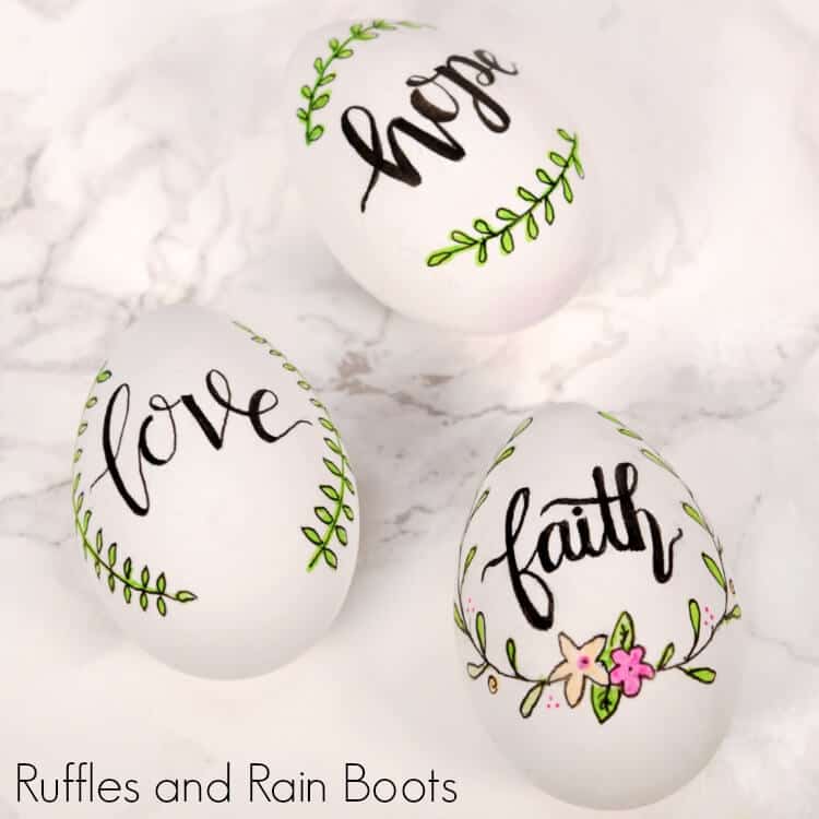 Square close up image of three hand lettered Easter eggs for farmhouse decor.