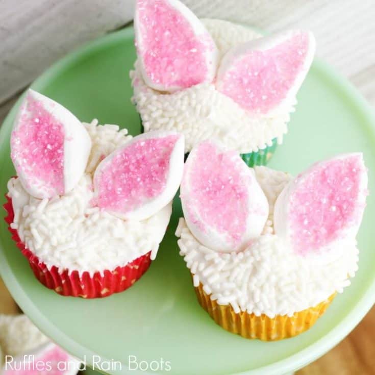 close up of three Easter bunny cupcakes on green plate