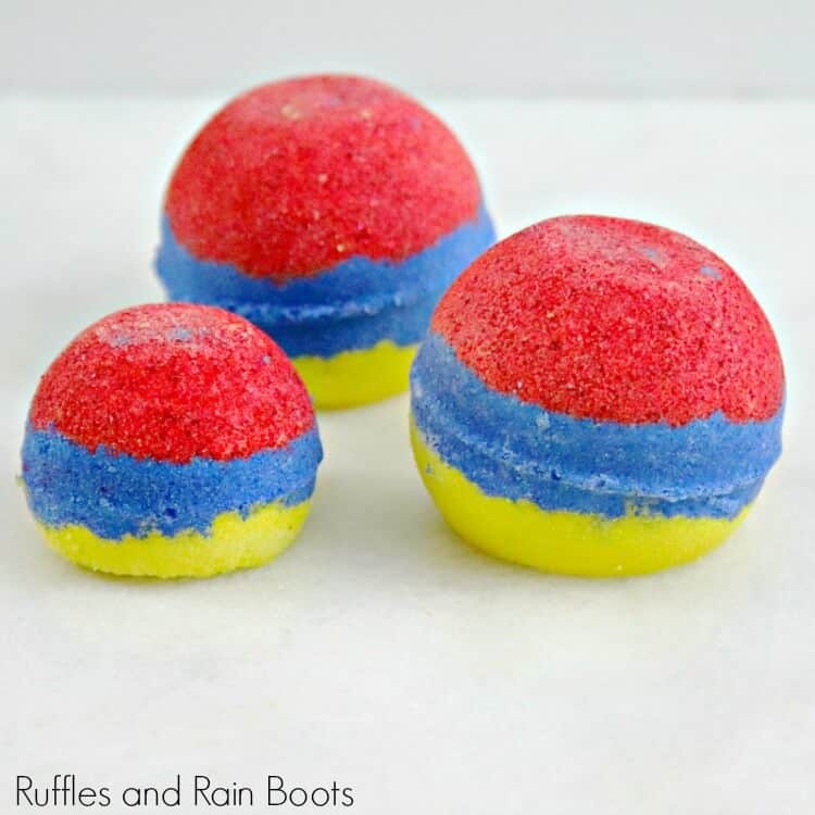 side view of red, blue and yellow snow white bath bombs on a white background