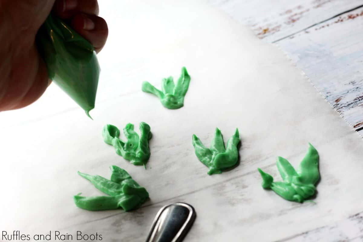 piping carrot tops using green melted chocolate on parchment paper and letting dry