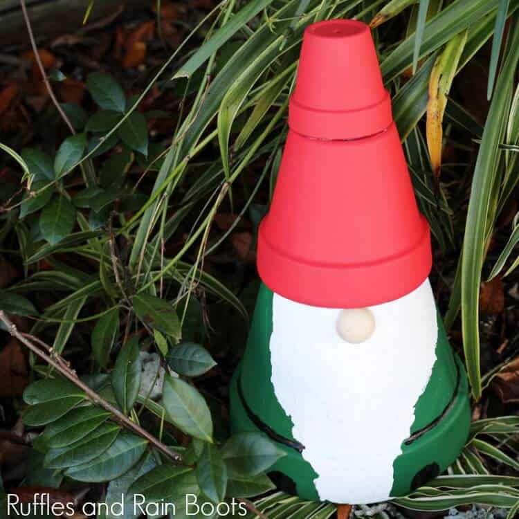 clay pot gnome statue in front of green foliage