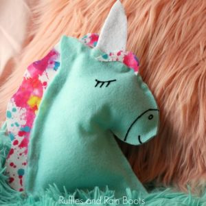 close of of unicorn pillow on fur rug