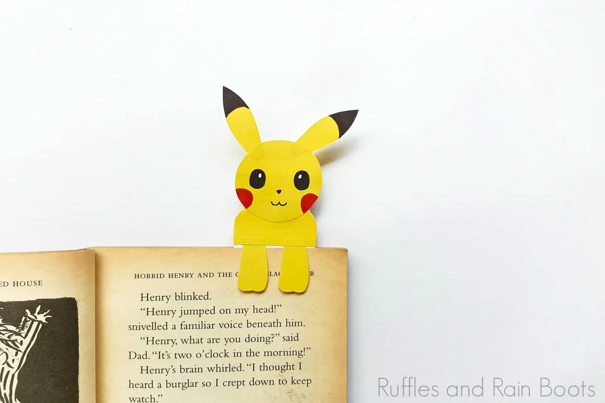 pikachu bookmark hug style on a book on a white background