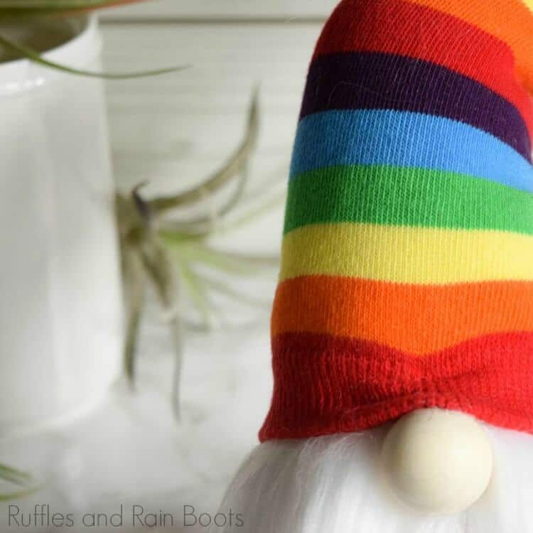close up of nordic gnome with a twisty hat on white marble background with air plants