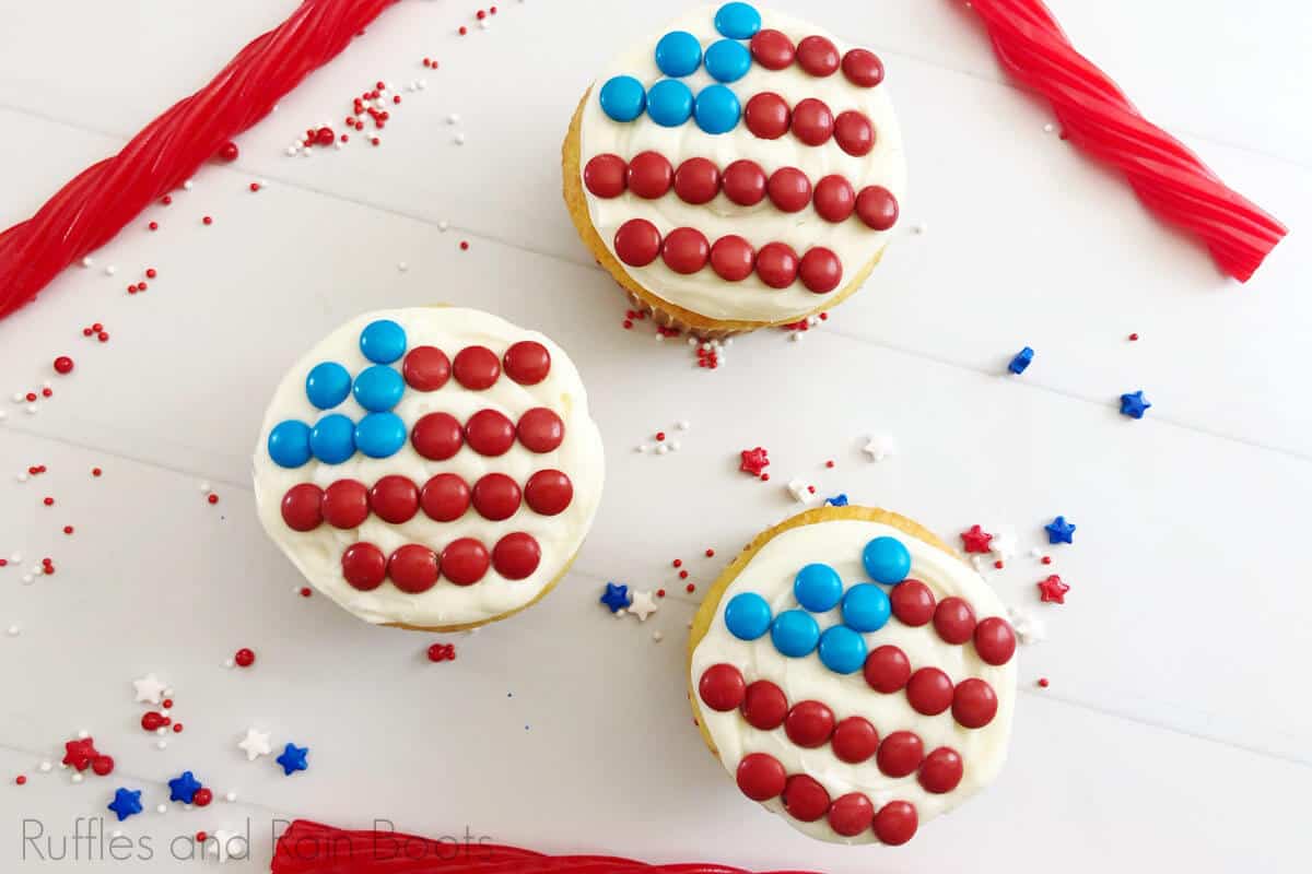 overhead view of 3 flag cupcakes, white cupcakes decorated with a flag made of candy, on a white background