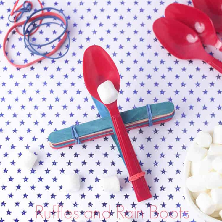 overhead view of kids marshmallow catapult on a blue and white polka dot background