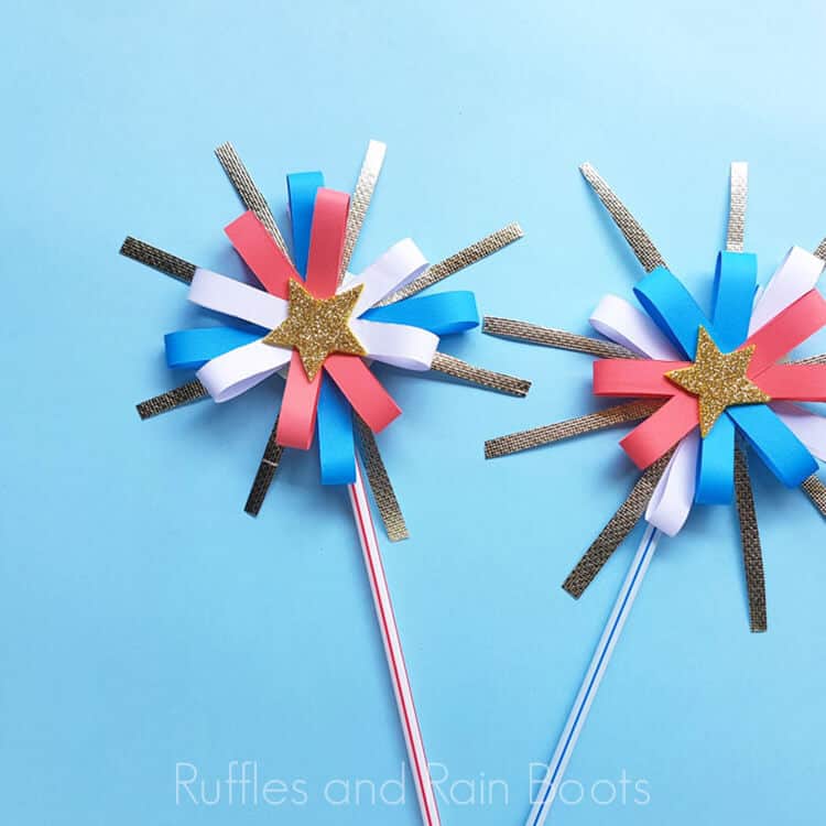 two paper fireworks craft for kids on a blue background