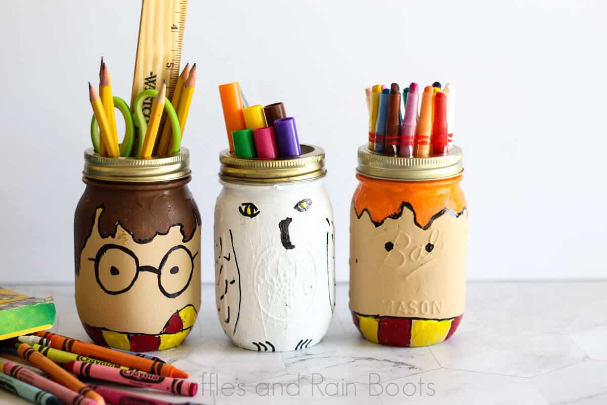 Harry Potter mason jars painted mason jar craft for kids filled with school supplies on a white background