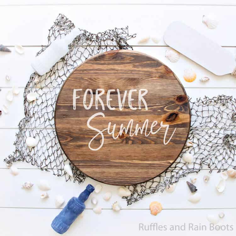 Forever Summer free summer cut file for Cricut Wood Round Sign on a fishing net with sea shells scattered around with an oar and bottle on a white background