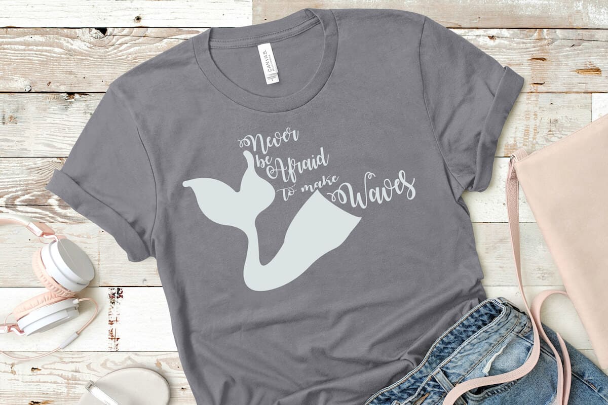 Never be Afraid to Make Waves mermaid free svg on t-shirt with jeans and headphones on a beige wood background