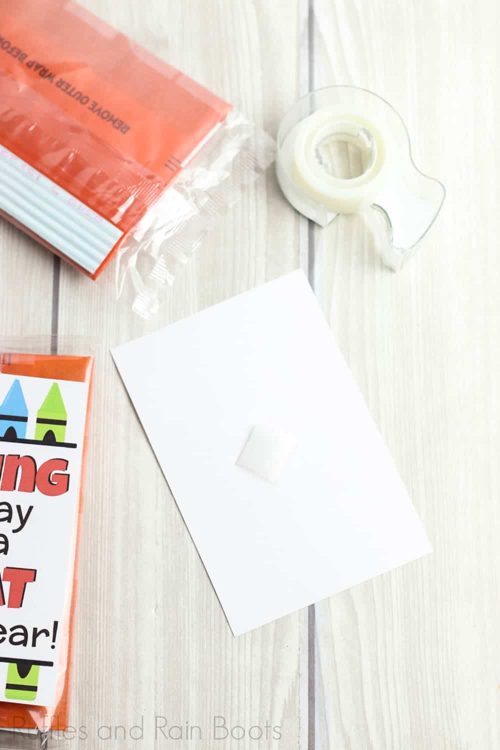 tutorial to make a simple back to school teacher gift by adding tape to back of tag for popcorn gift