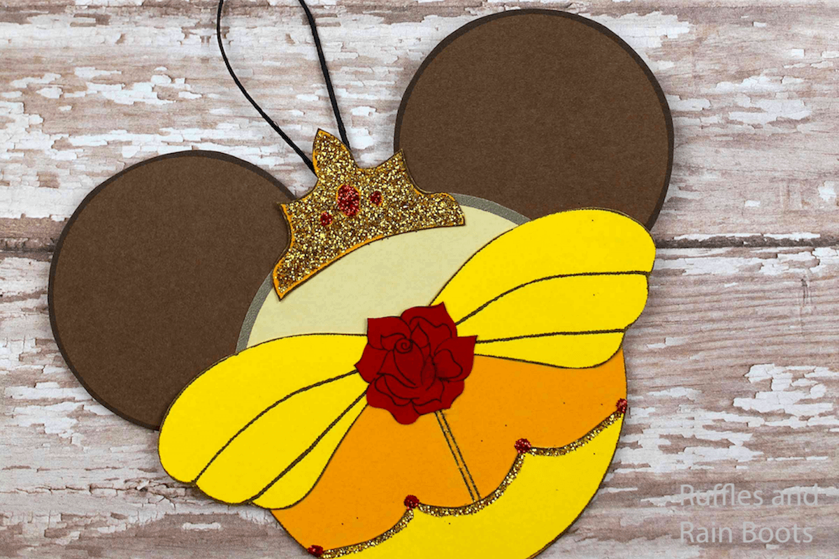 beauty and the beast ornaments for christmas on a wood background
