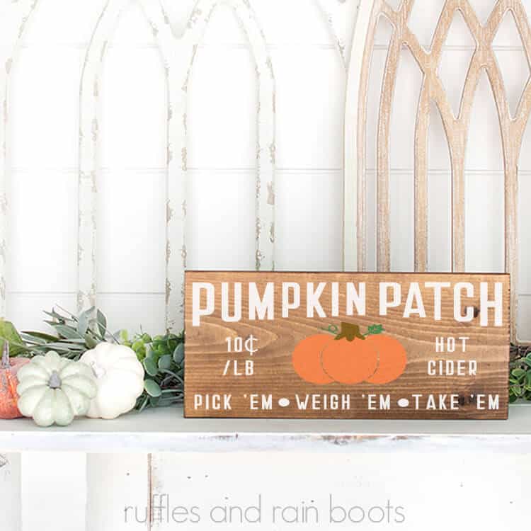 Mounded Pumpkin Patch SVG on a wood sign sittin gon a mantel with some pumpkins in front of a white background
