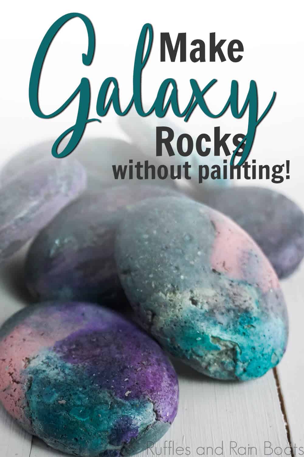 side view of black pink blue and purple rocks on a white table with text which reads make galaxy rocks without painting