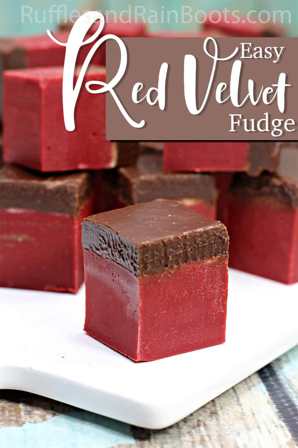 single red velvet and dark chocolate fudge on a white plate with text which reads easy red velvet fudge recipe