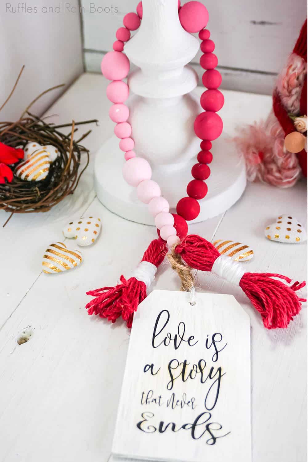 pink to red ombre farmhouse bead diy for valentines on a white table with a white candle holder