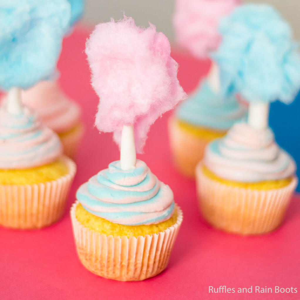Closeup of cotton candy cupcakes for a pool party on pink and blue background.