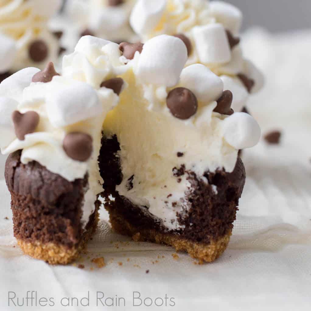 Open inside view of marshmallow fluff filled S'mores cupcakes with graham cracker crust.