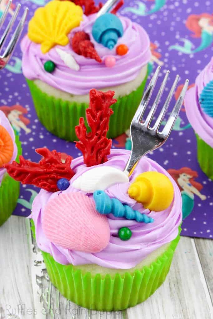 vertical image of 2 Princess Ariel cupcakes on an ariel image background