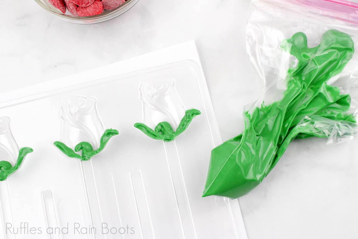 process photo of the green frosting being piped into the rose flower mold to harden on a white background.