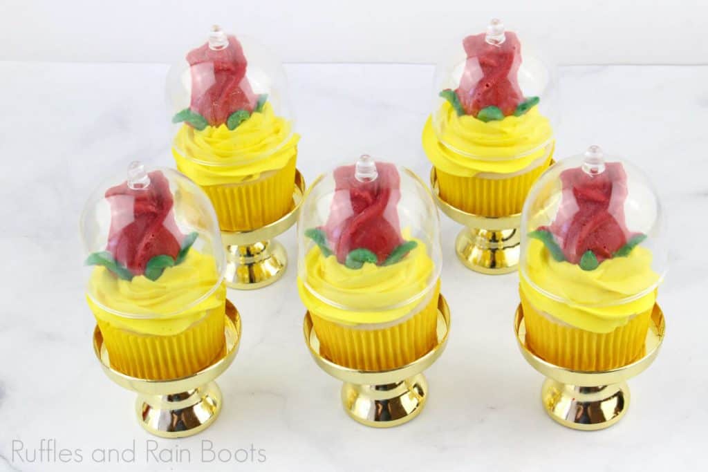 5 Princess Belle cupcakes on the cupcake stands with a white background