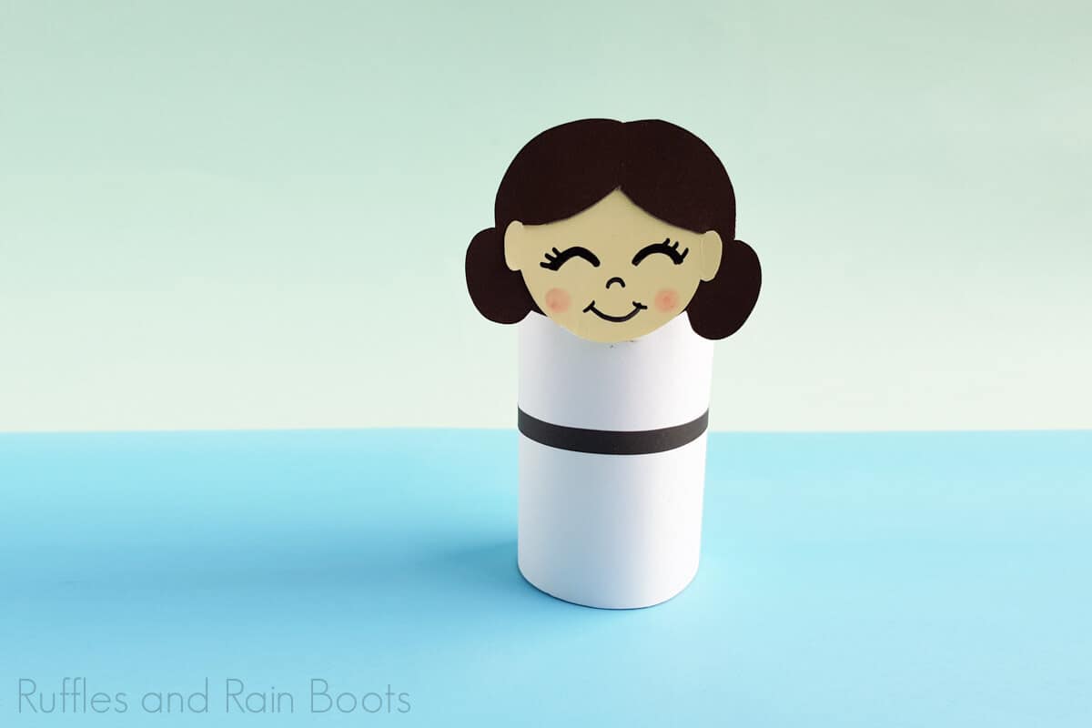 Horizontal image of Princess Leia paper roll doll on a blue and green background.