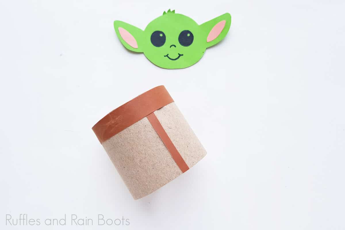 Horizontal image of baby yoda's body and head ready to be attached on a white background.