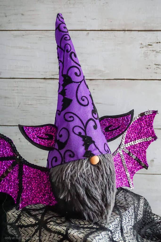 Purple dollar tree bat gnome DIY for Halloween on wood and black background.