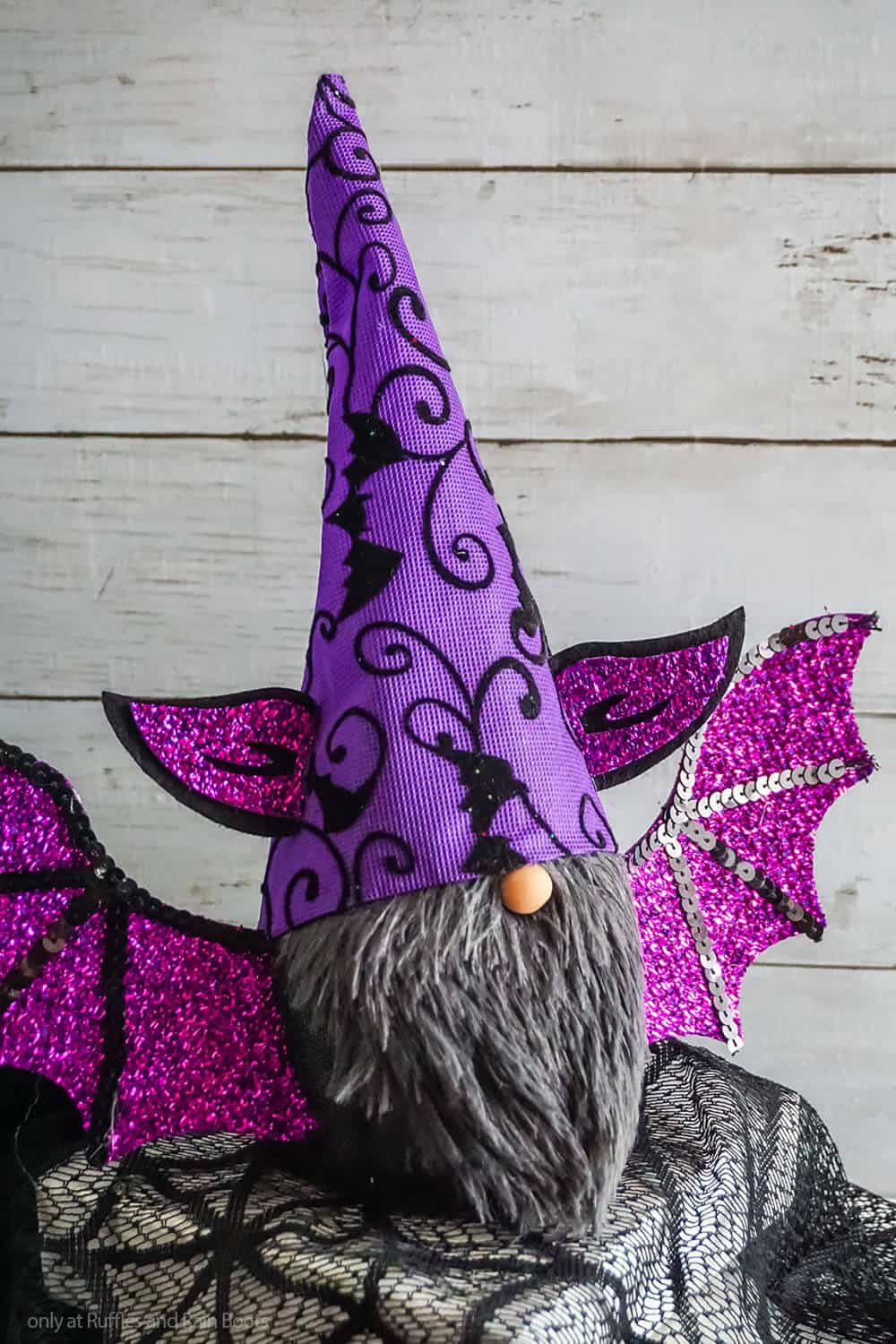 Close up of a Dollar Tree vampire bat gnome DIY with a gray beard and purple wings and gnome hat.