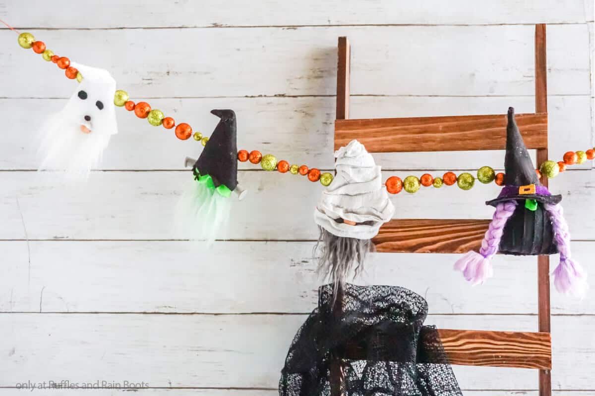 Two small white ghosts crafts, felt sheets, scissors, thread, needle on  lilac wooden background. Hand Halloween decor idea for kids. Halloween  sewing craft Photos