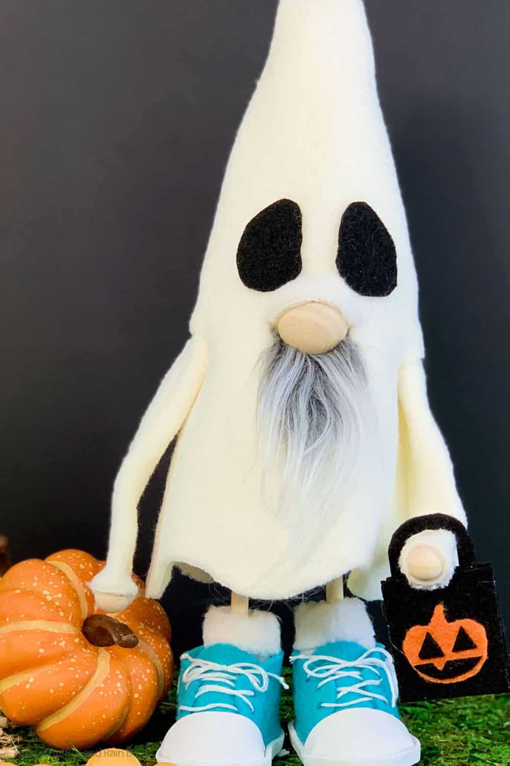 Vertical image of a DIY Halloween gnome in a costume with tennis shoes and a trick or treat bag.