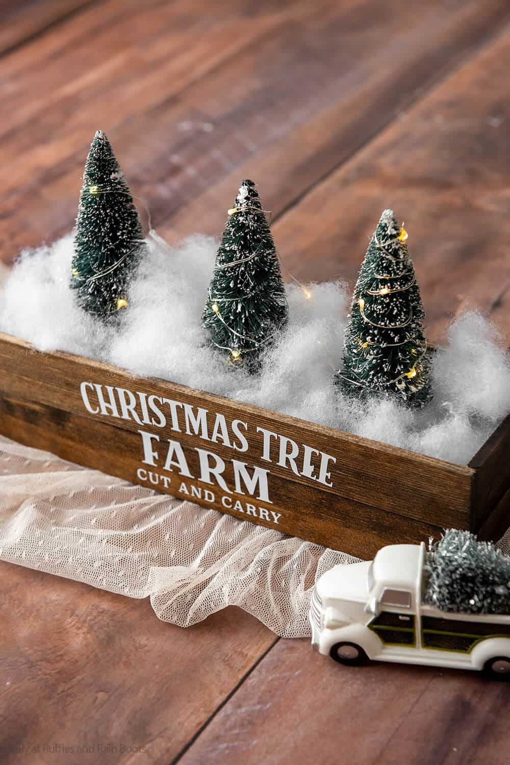 Vertical image closeup of a Christmas table centerpiece made to look like a Christmas tree farm.