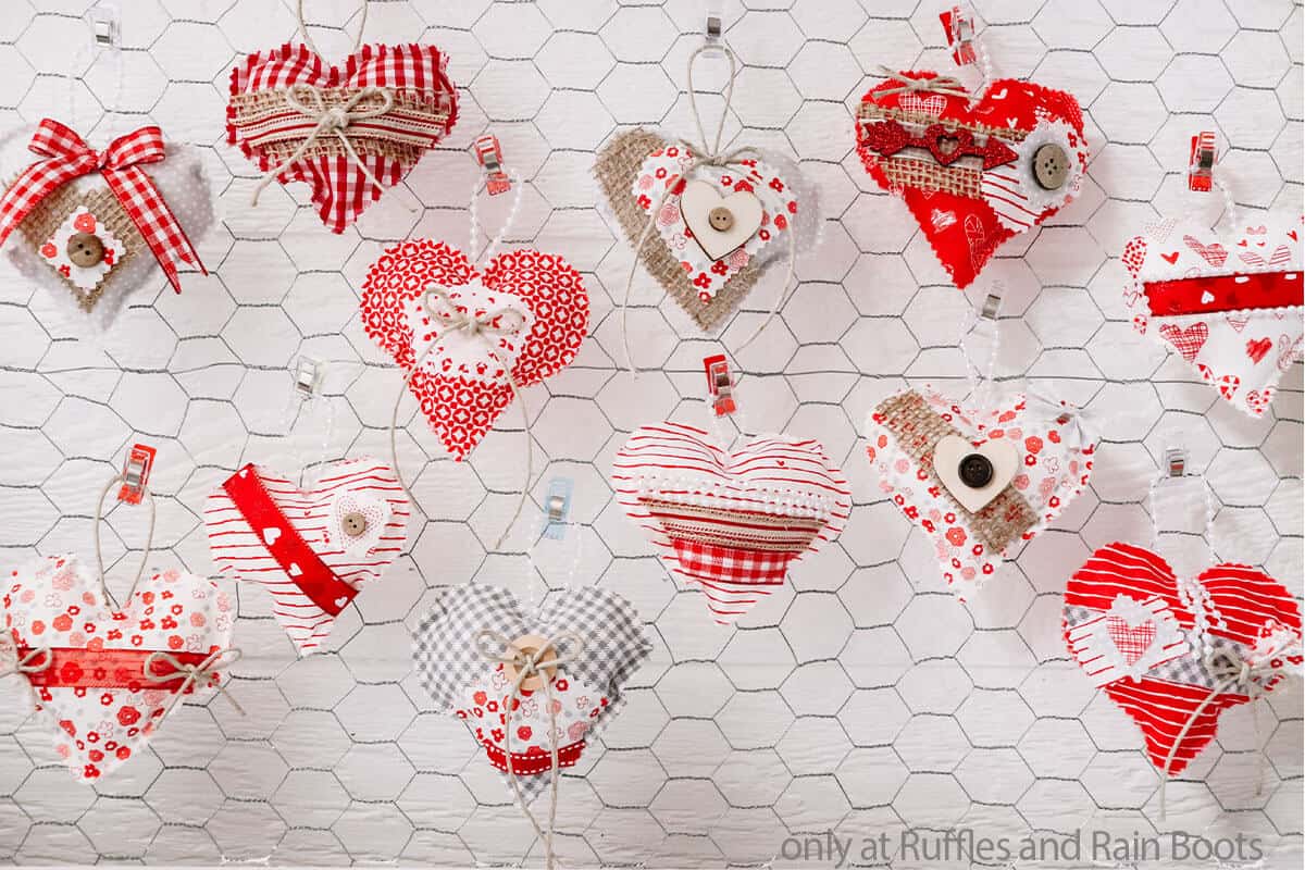 image of 12 Valentines heart ornaments with a mix of red, white, and pink fabrics, twine, and buttons for a farmhouse feel posted on chicken wire.
