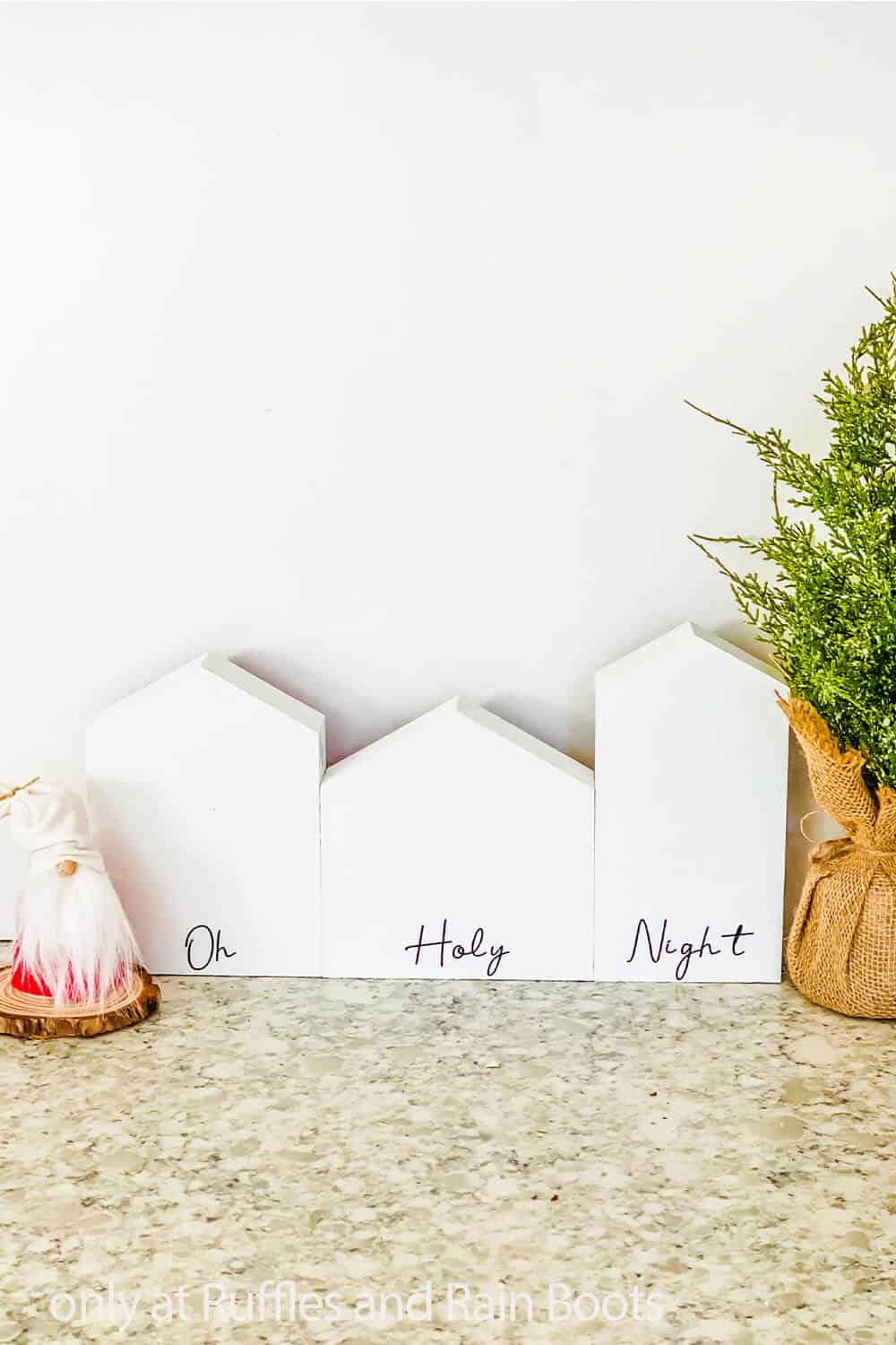 Vertical image of Dollar Tree Christmas craft made with small wood house shapes. 