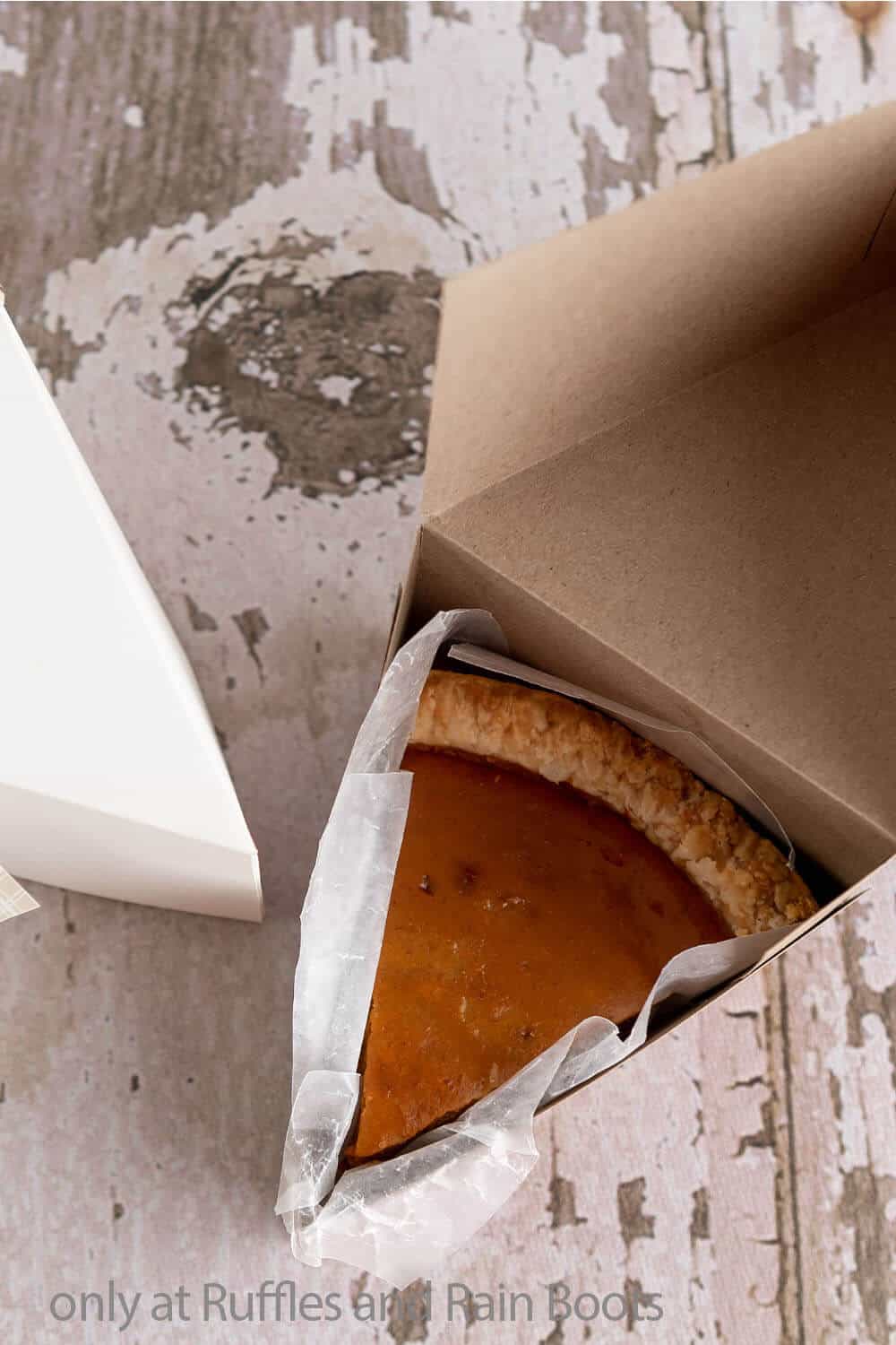 Overhead view of a piece of pumpkin pie on parchment paper in a Cricut made to go pie slice holder on a cracked wood background.