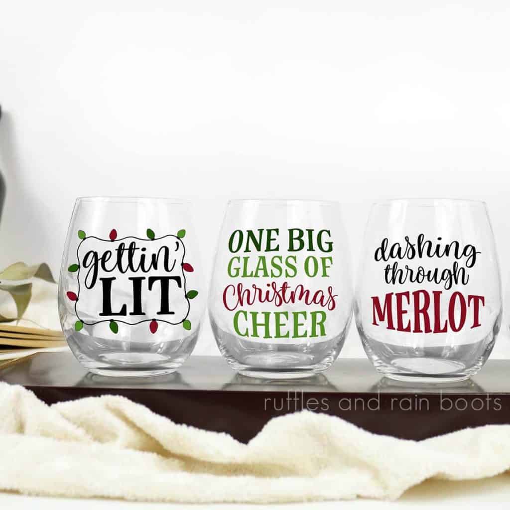 square close up image of three Christmas wine glass SVG files in red black and green permanent vinyl on clear stemless wine glasses
