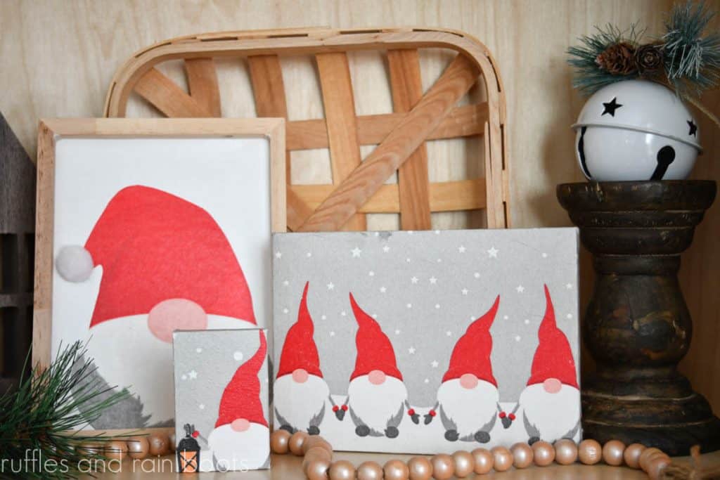 horizontal image of three Christmas gnome decoupage canvas crafts on a holiday background with tobacco basket farmhouse beads and ornament