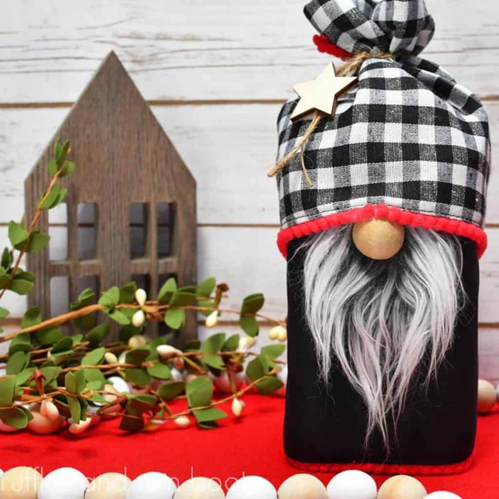 square image of a gnome treat jar made with a premade placemat on a holiday and wood themed background