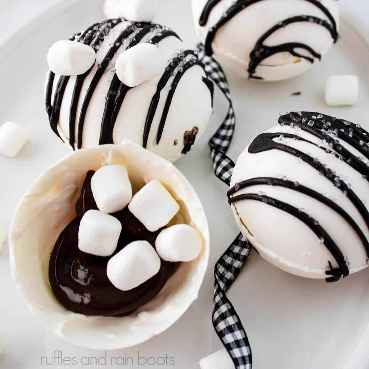 Square image of an open chocolate bomb showing Baileys Irish cream ganache recipe, mini marshmallows, and three completed coffee bombs on a white plate.
